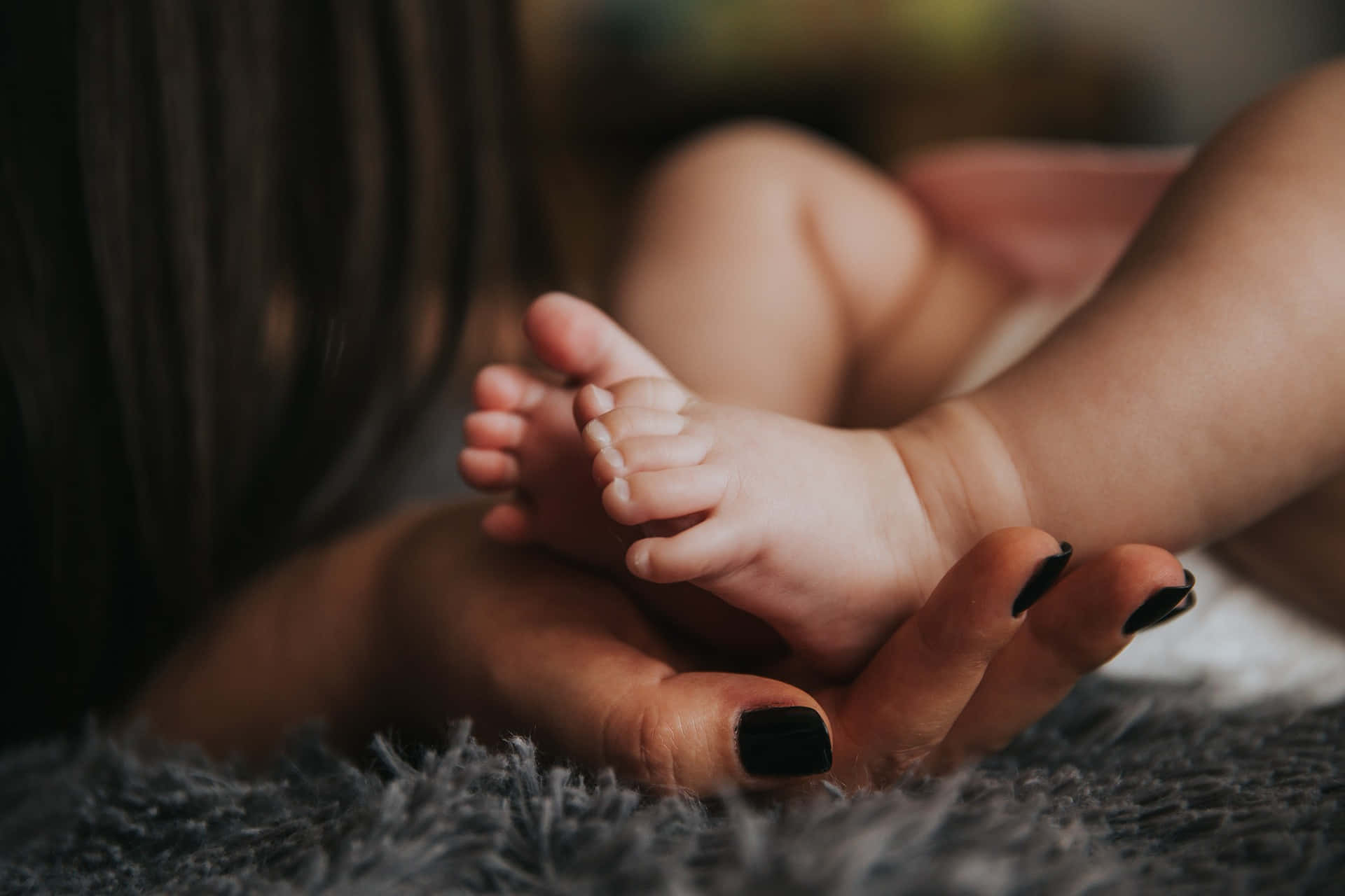 Photo Of A Mother's Hand Holding The Tangible Feet Of A Baby Background