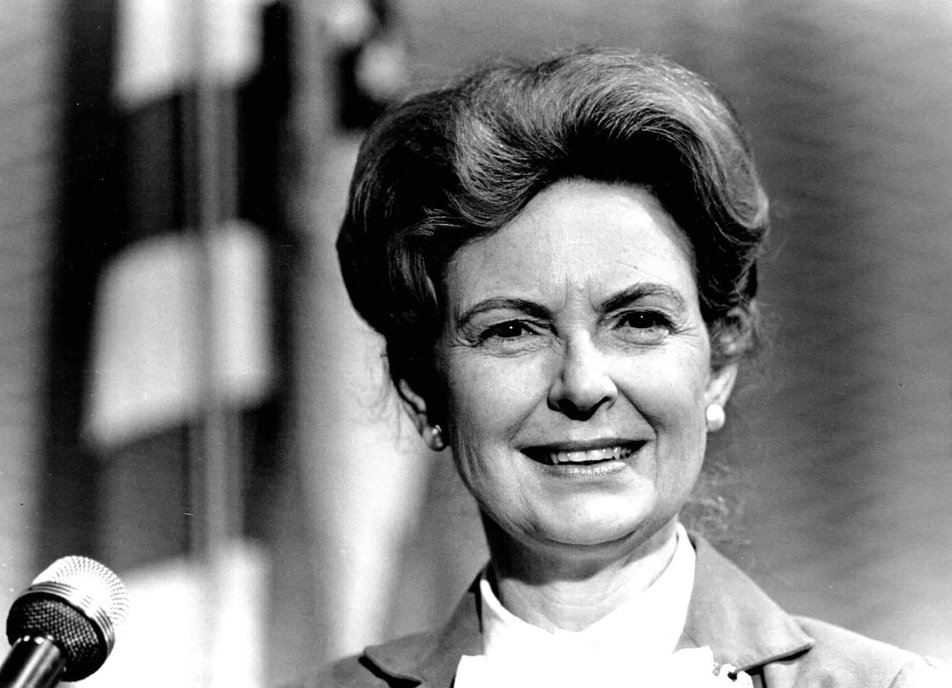Phyllis Schlafly Delivering A Speech At A Podium Background
