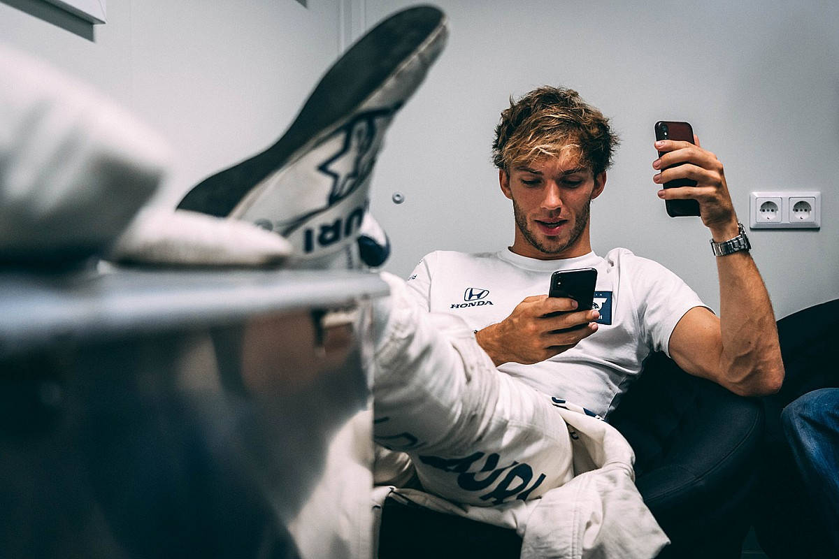 Pierre Gasly Leisurely Sitting With His Leg Up, Showcasing Effortless Style. Background