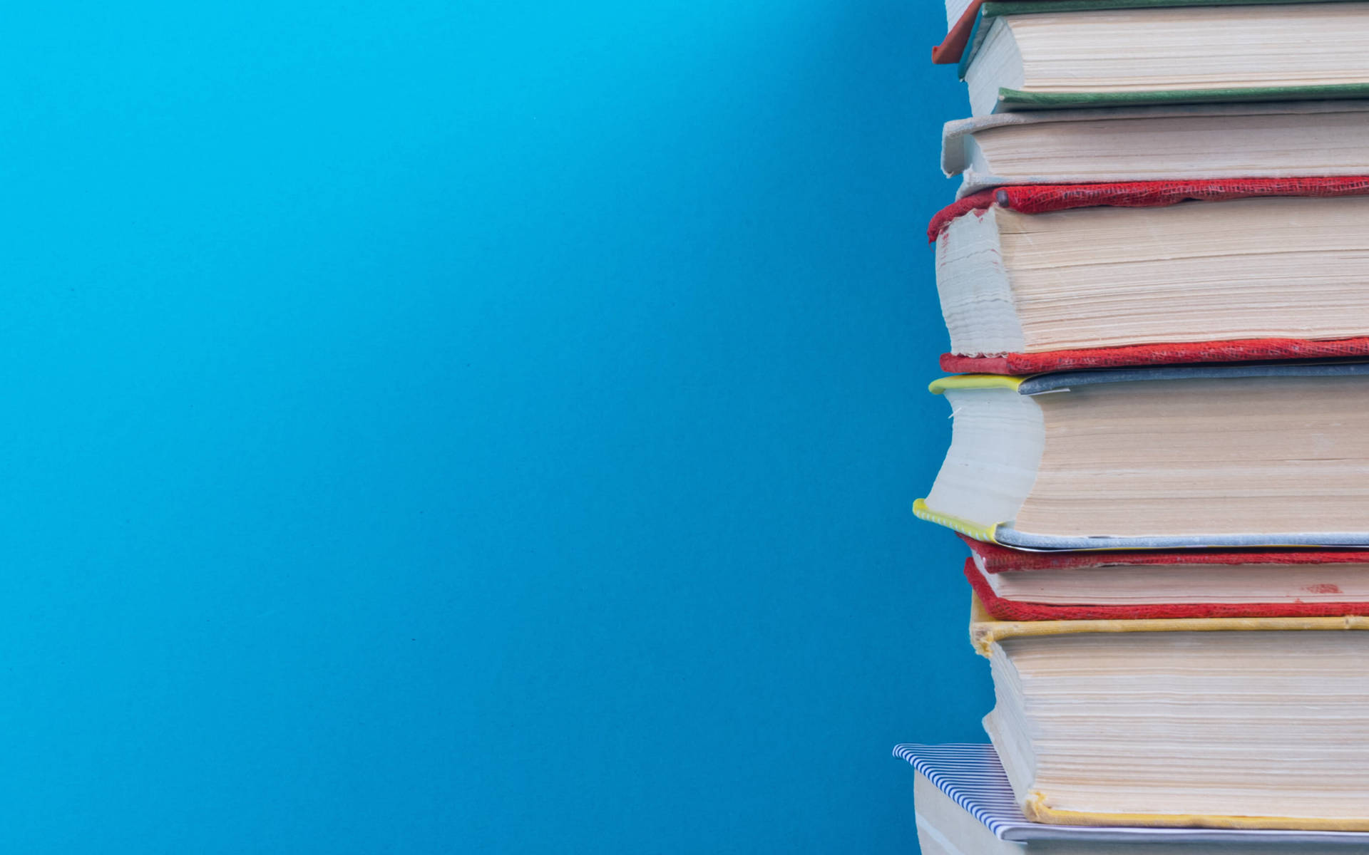 Pile Of Books On Blue Background Background