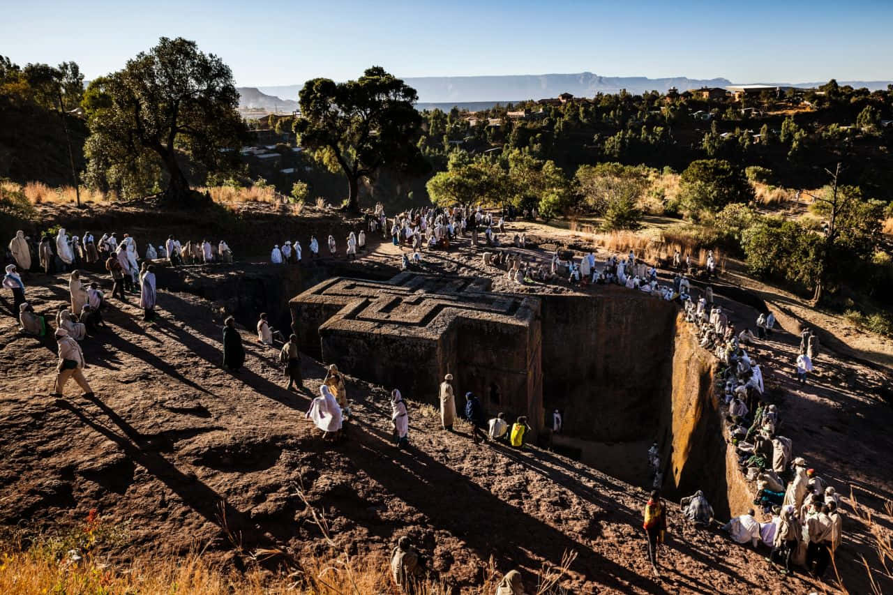 Pilgrims Around St. George Church In Lalibela Background