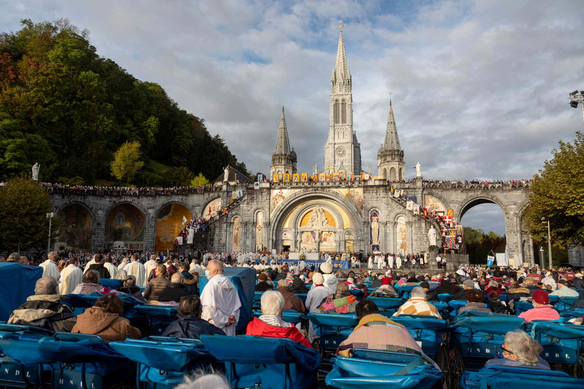 Pilgrims At The Holy Lourdes Grotto Sanctuary In France Background