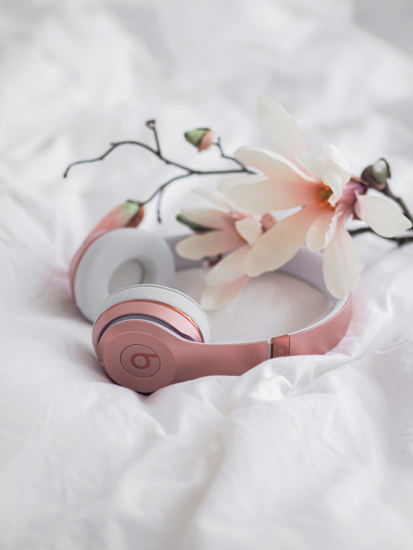 Pink Headphones On A White Bed With Flowers