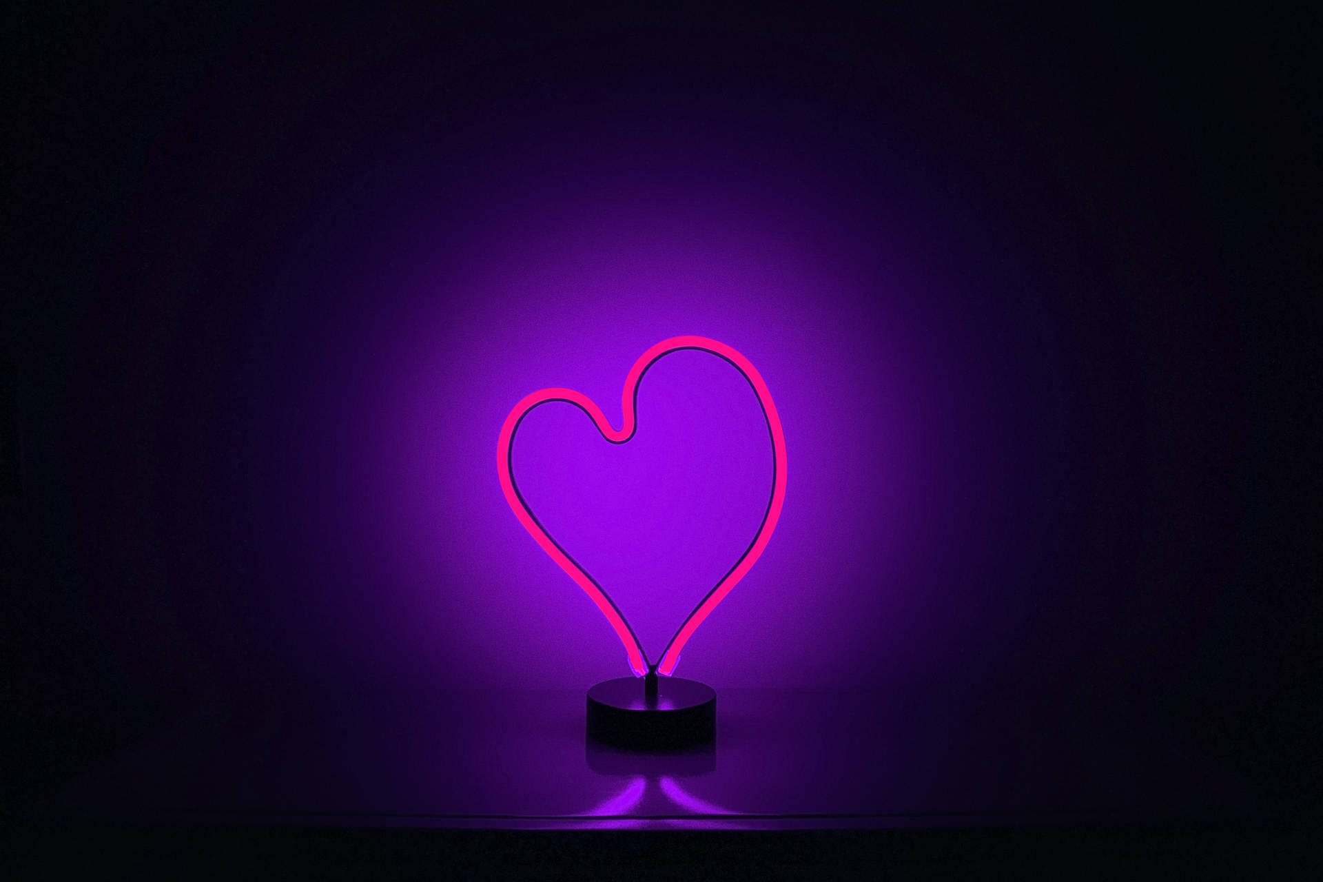 Pink Neon Heart And Purple Glowing Light Background