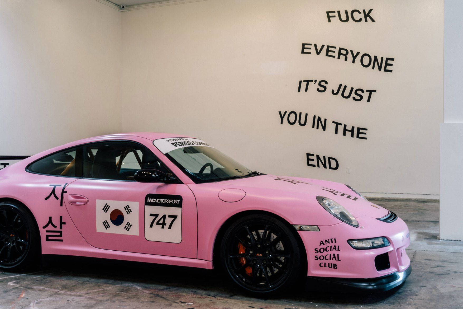 Pink Sedan Showcasing Anti Social Club Logo Background