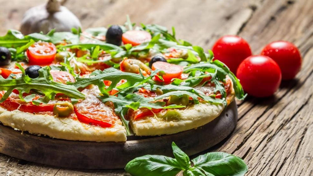 Pizza Topped With Arugula, Tomato, And Olive