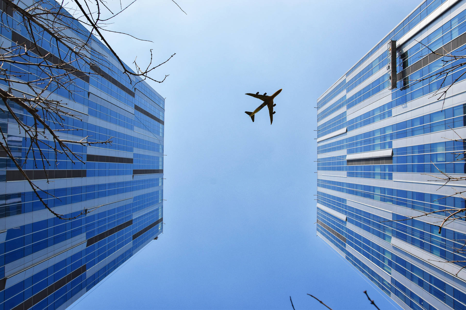 Plane Flying Through City Background