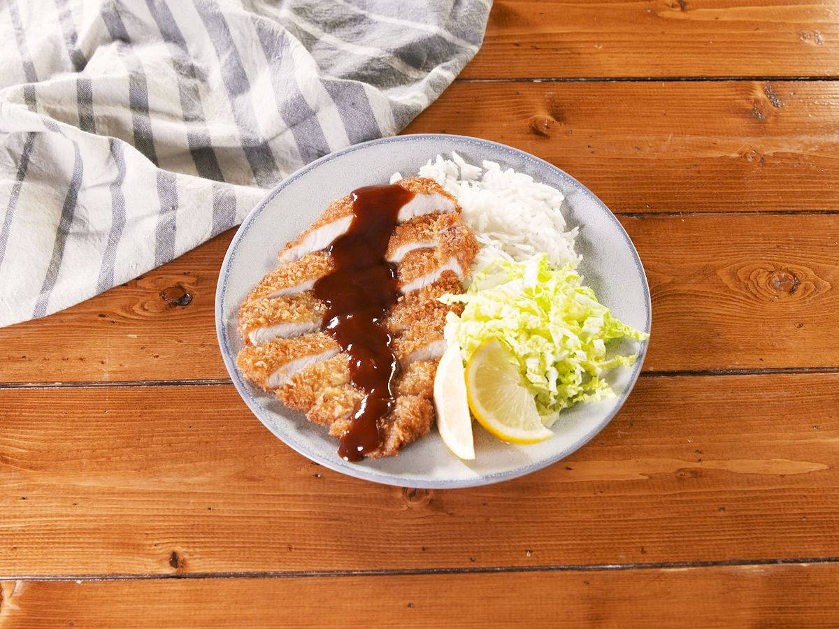 Plate Of Saucy Tonkatsu On Wooden Surface Background