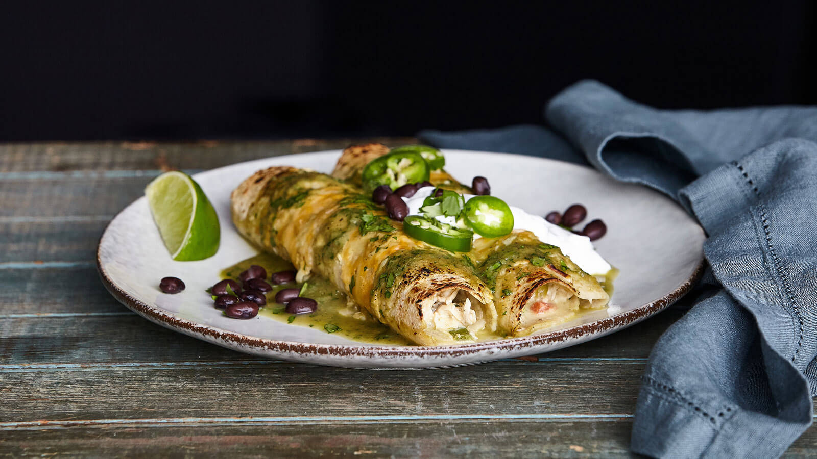 Plate Of Spicy Enchiladas With Black Beans Background