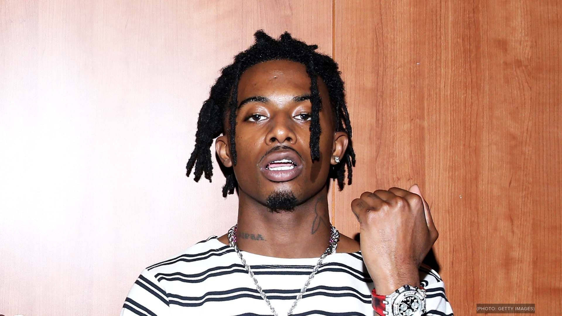 Playboi Carti Holds Fist Up In Adrenaline And Progress. Background