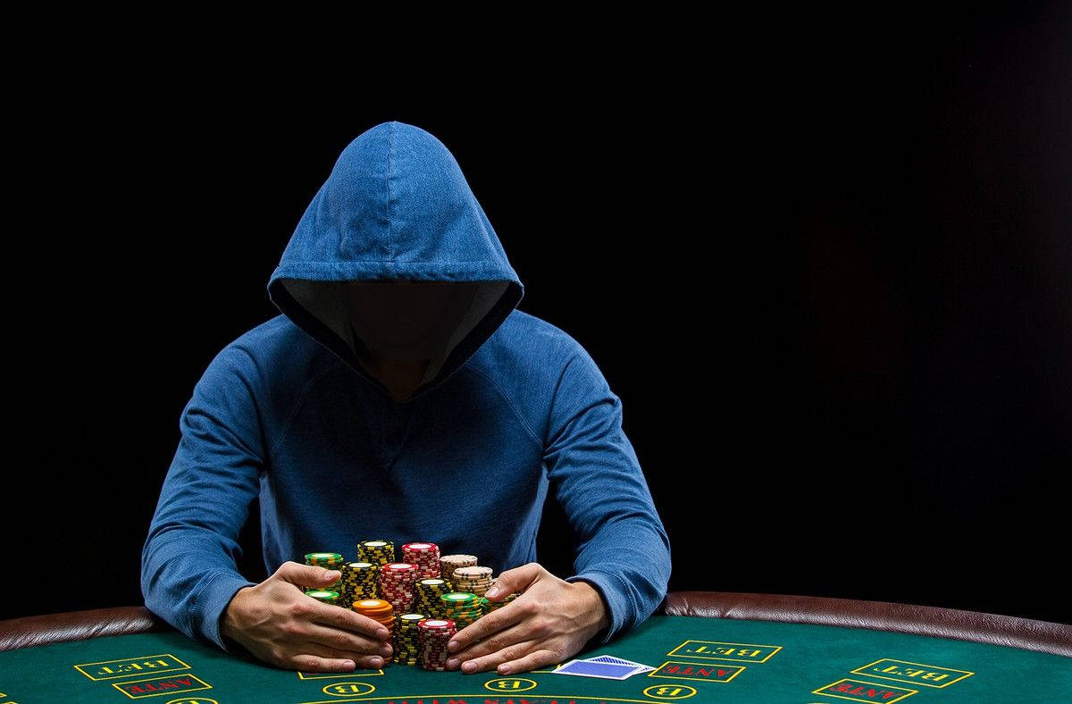 Player Blue Hoodie Sitting At A Poker Baccarat Table Background