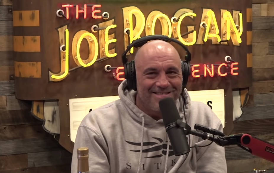 Podcast Host Joe Rogan With Show Logo Background