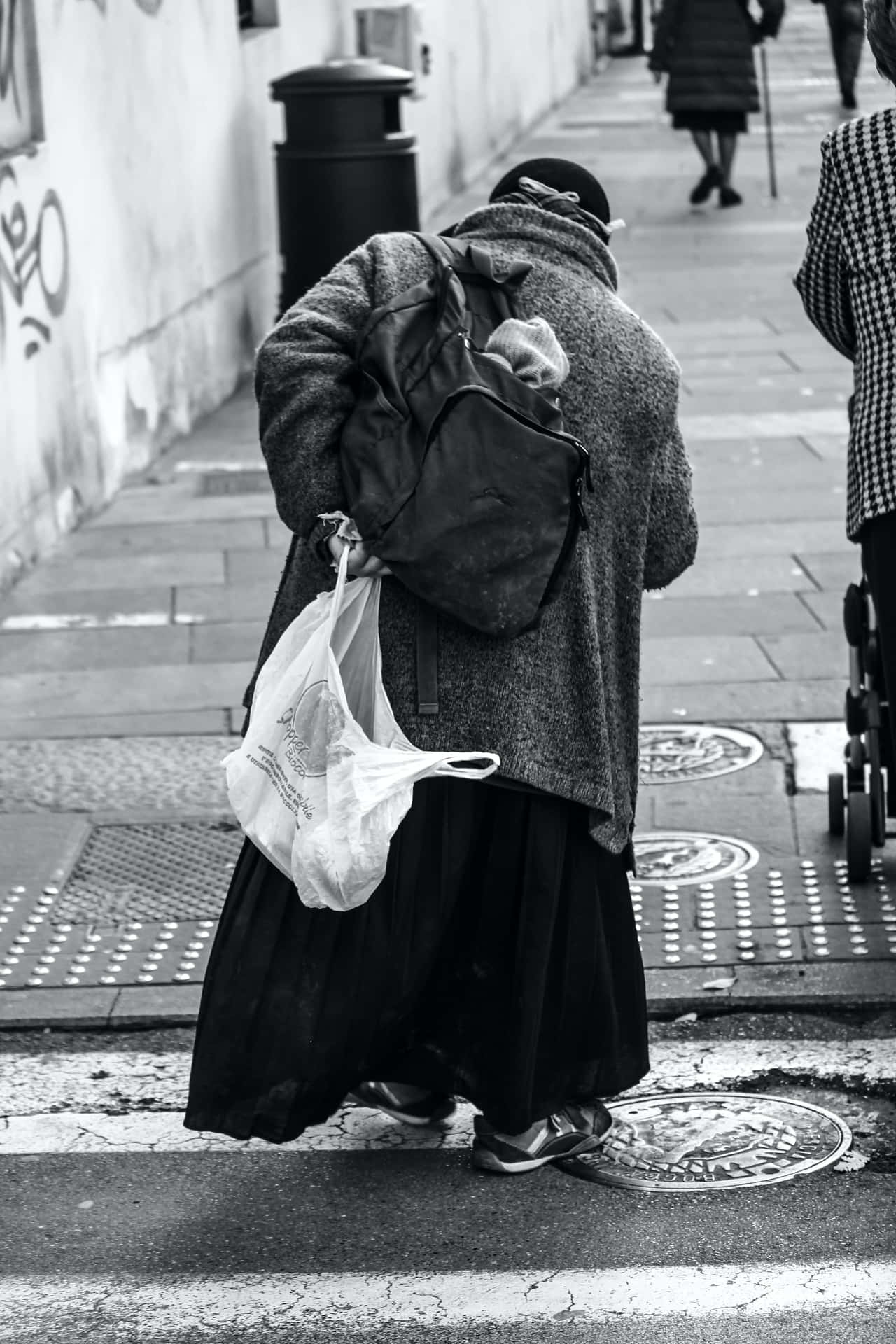 Poor Old Woman Walking Beside The Street Background