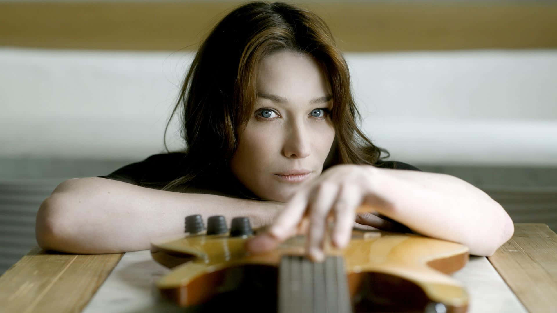 Pop Icon Carla Bruni Strumming Her Guitar Background