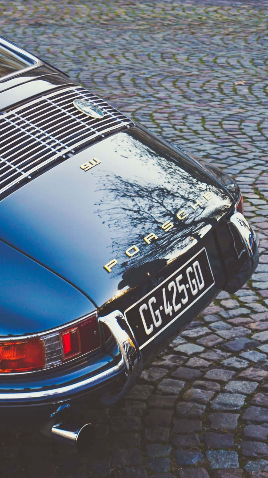 Porsche 911 - A Classic Car Parked On A Cobblestone Street Background