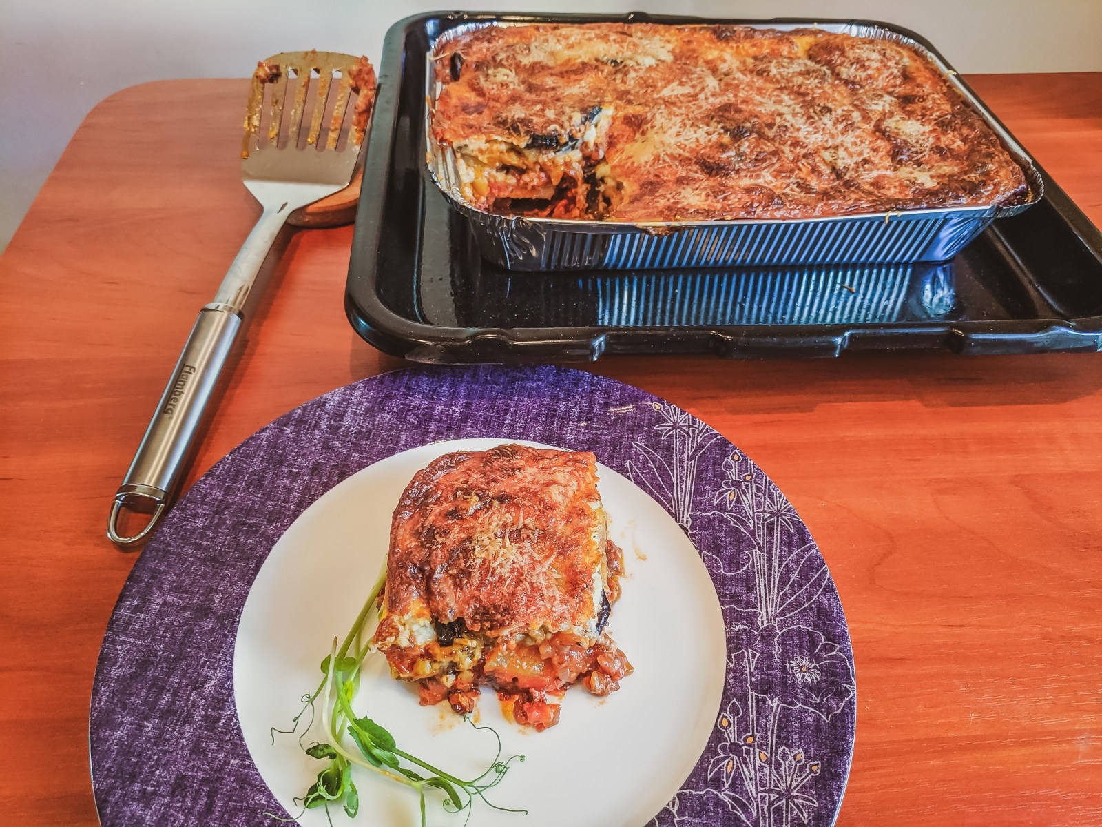 Portion Of Moussaka From A Tray Of Baked Casserole Background