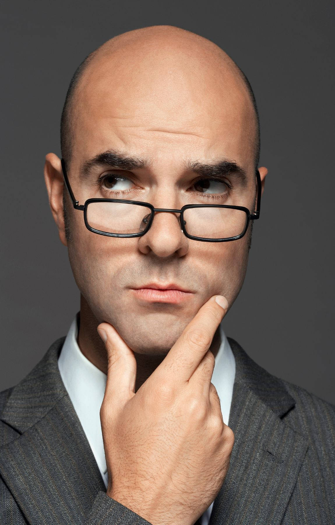 Portrait Of A Mature Bald Man In Glasses Background