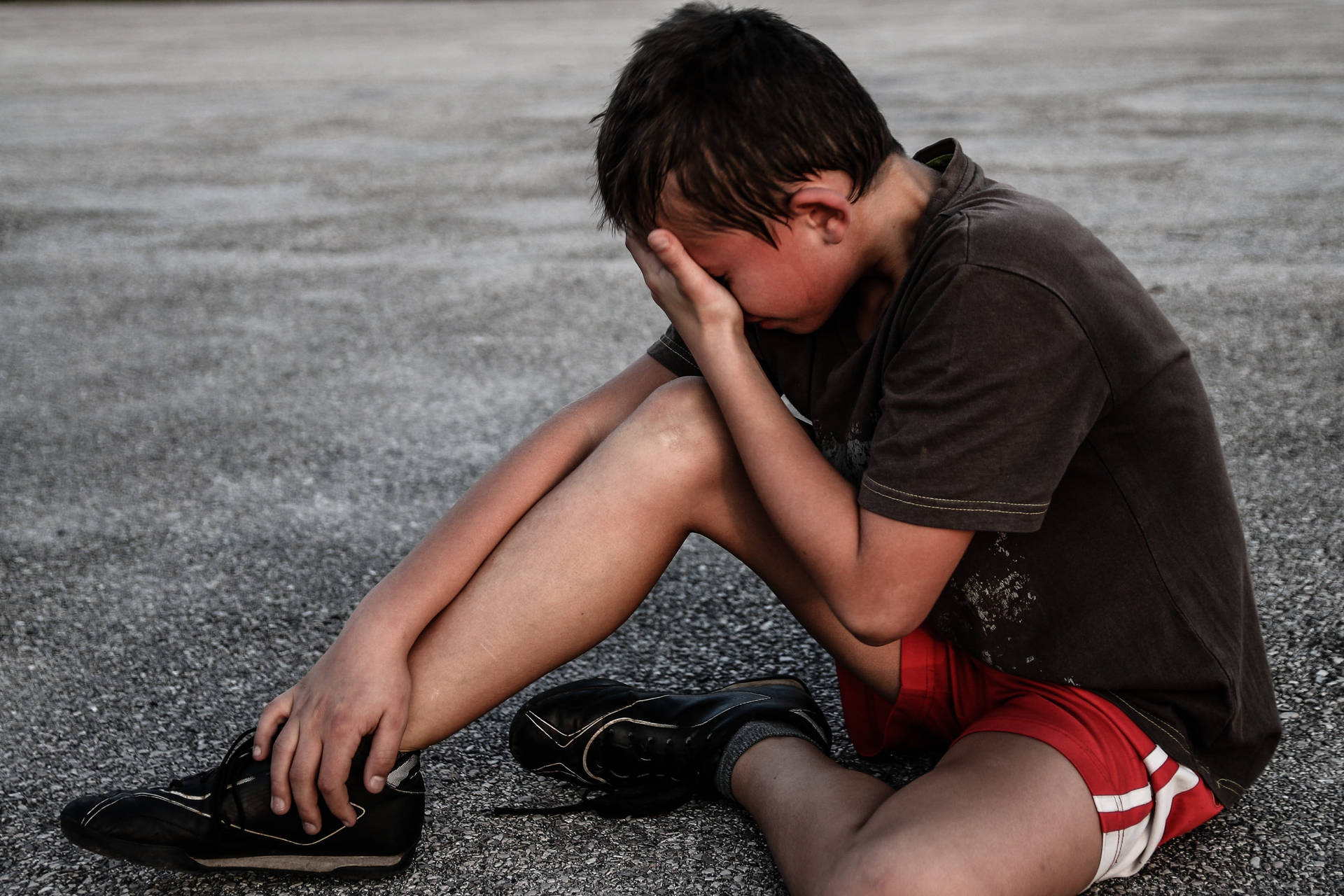 Portrait Of A Tearful Young Boy Displaying Emotion Background