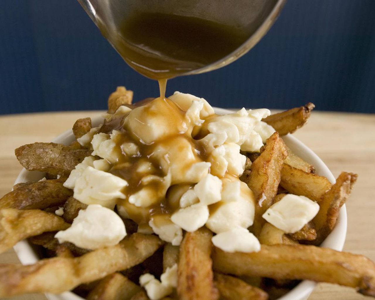 Pouring Hot Gravy To Poutine Background