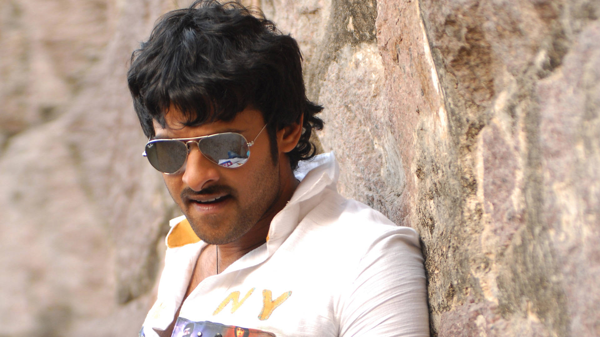 Prabhas Hd Leaning On A Rock Background