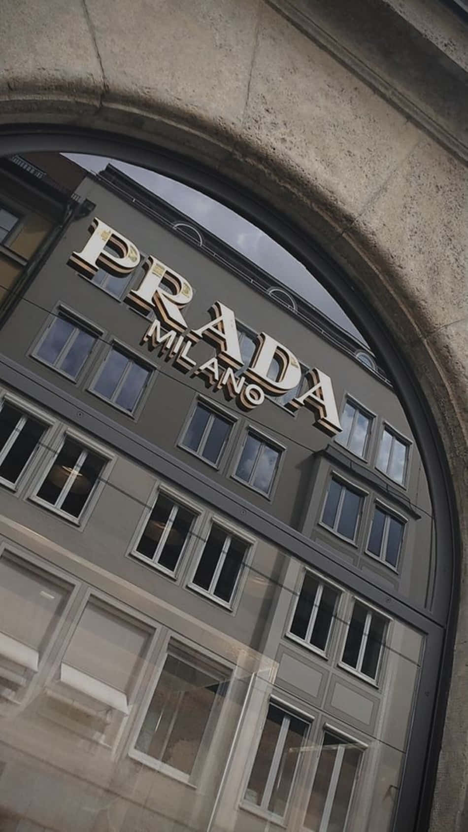 Prada - A Mirrored Building With A Sign