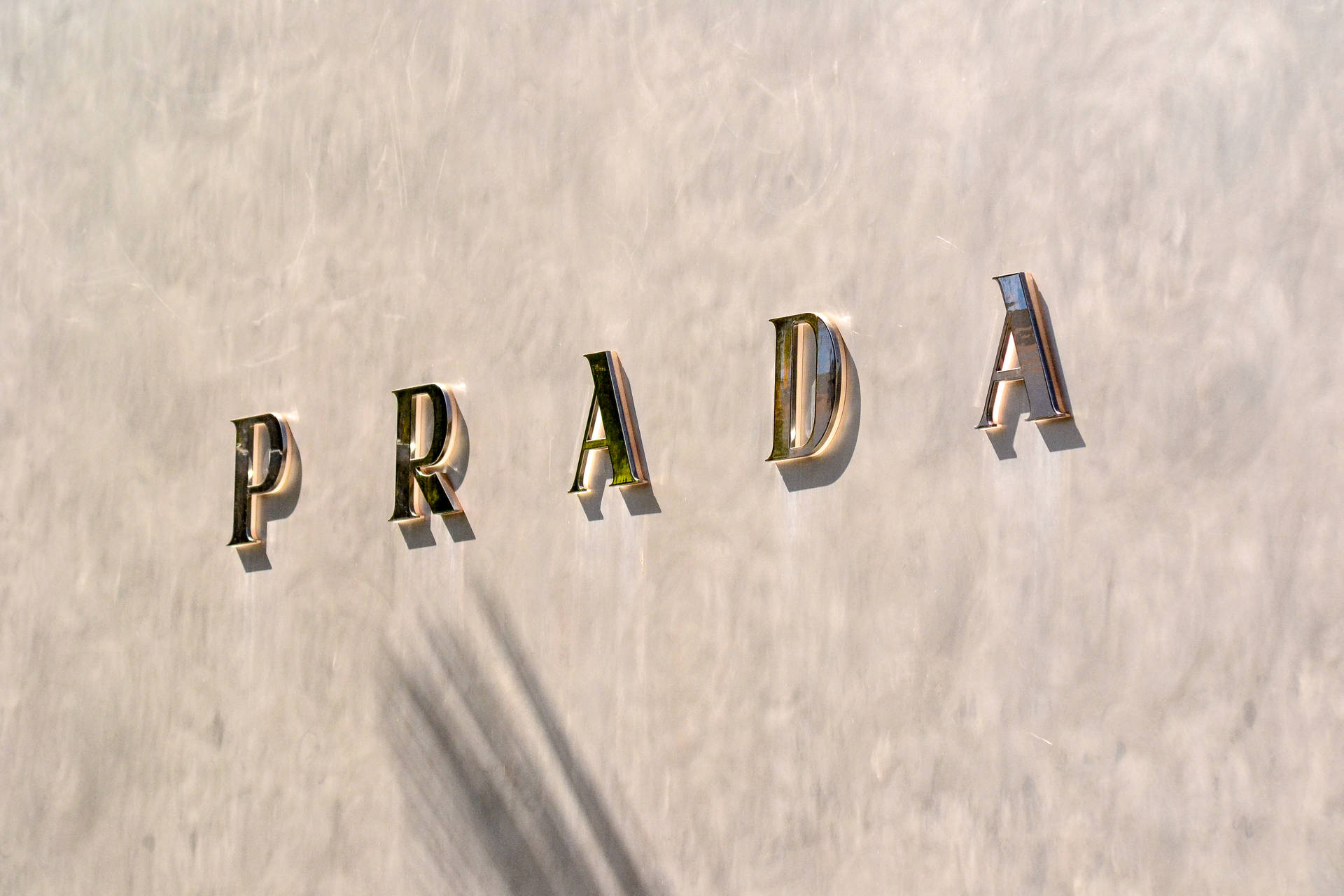 Prada Gold Letters On Wall Background