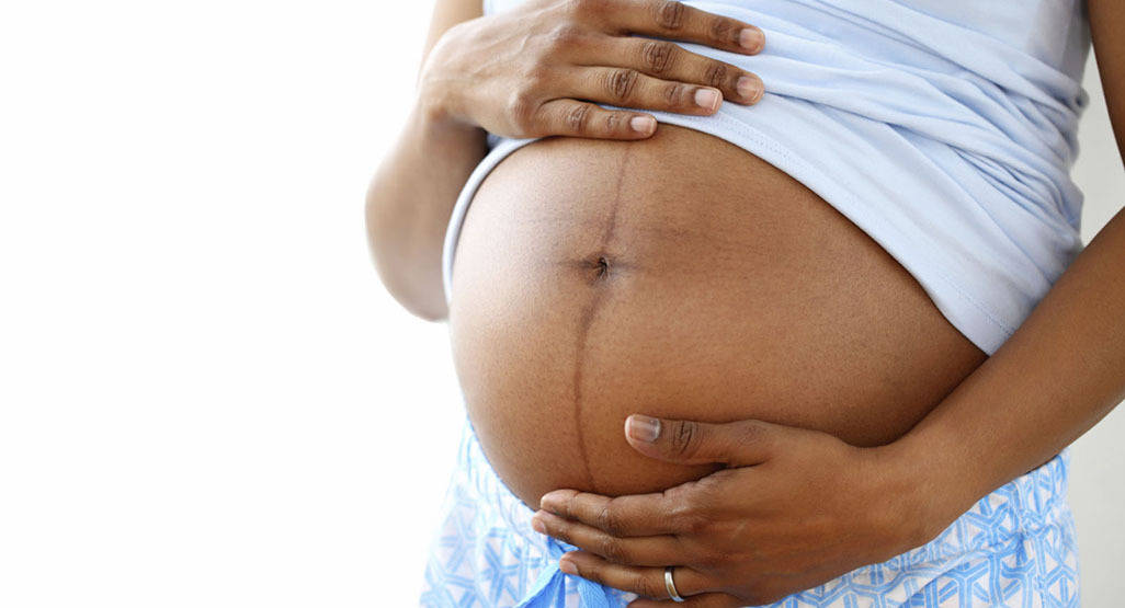 Pregnant Belly White Shirt Blue Bottoms Background