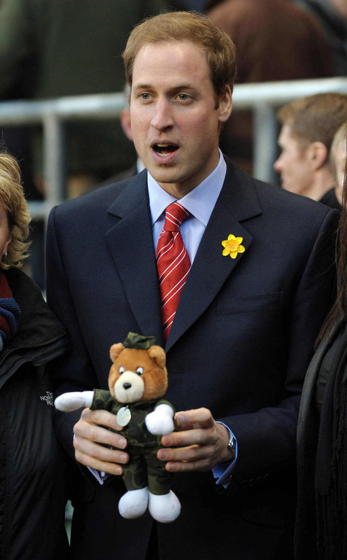 Prince William Smiling While Holding A Stuffed Toy Background