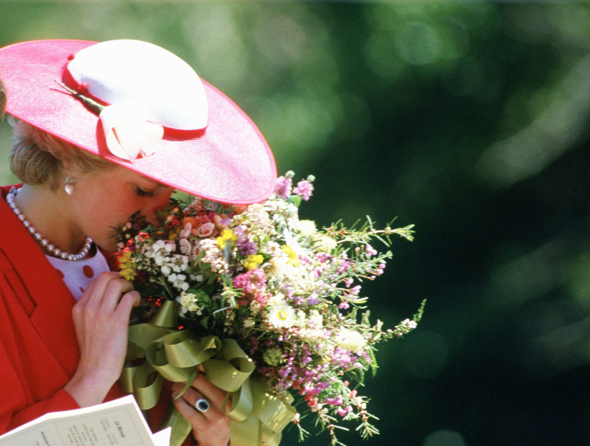 Princess Diana Gracefully Holding A Bouquet Of Flowers Background