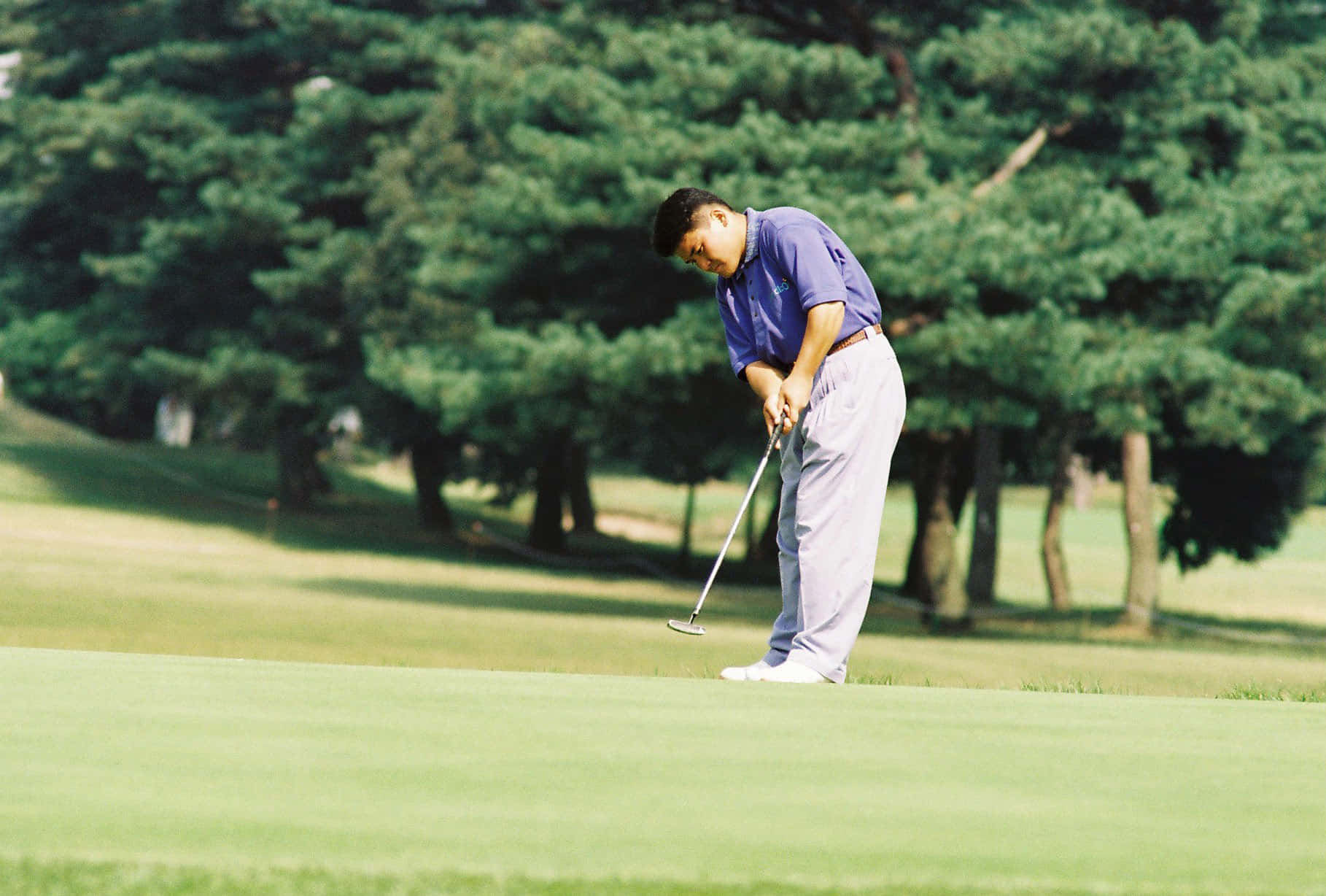 Pro Golfer Shigeki Maruyama In Steady Putting Pose Background