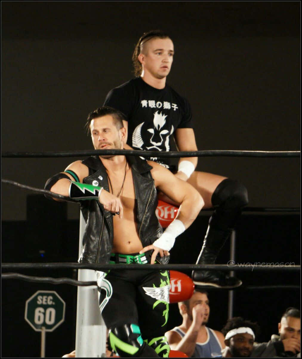 Pro Wrestlers Alex Shelley And Partner In Action At Impact Wrestling Background