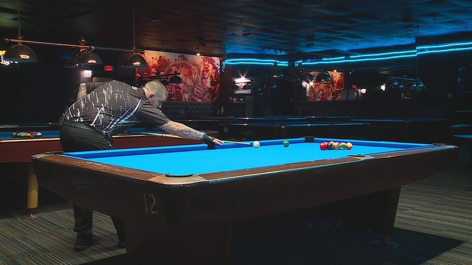 Professional Billiards Player In Action On A Vibrant Blue Pool Table.