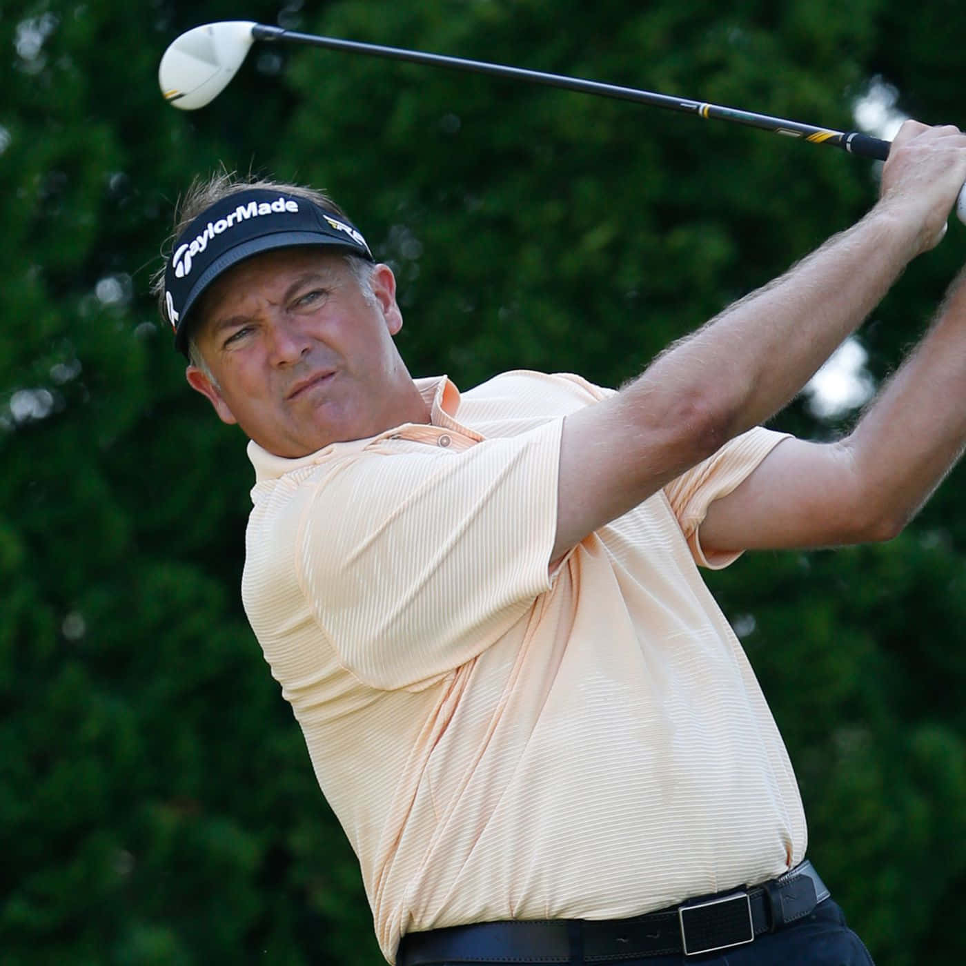 Professional Golfer Ken Duke Hits A Strong Swing On The Fairway Background