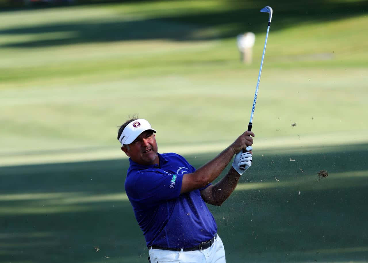 Professional Golfer Ken Duke Swings His Club On The Golf Course Background