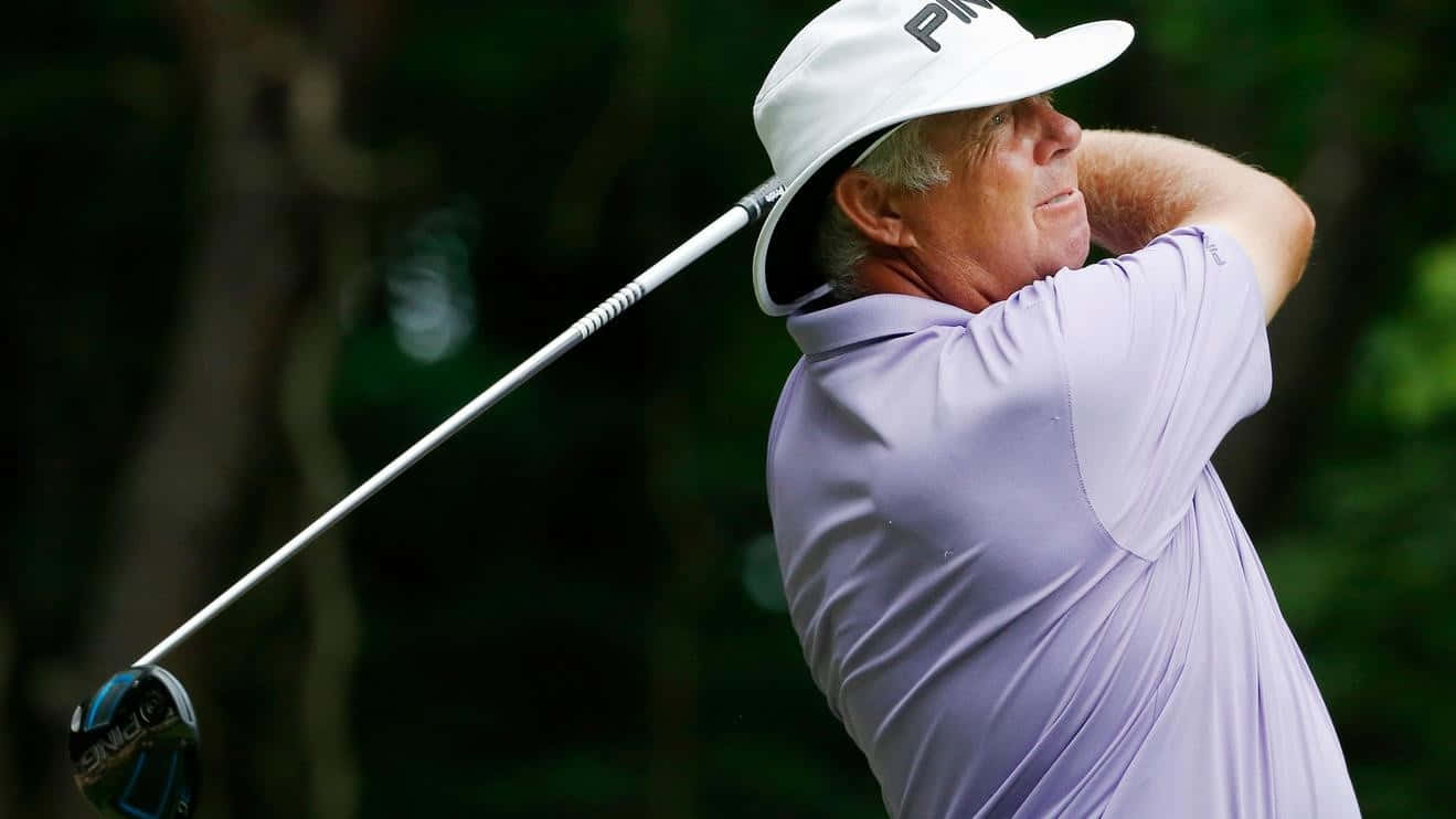 Professional Golfer Kirk Triplett Swinging A Golf Club Background