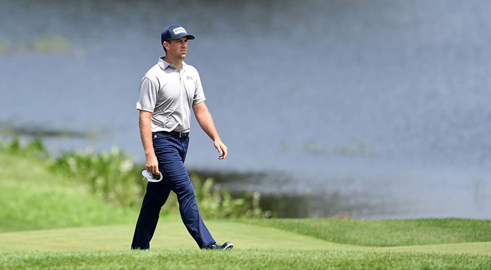 Professional Golfer Michael Thompson Strolling On The Golf Course Background