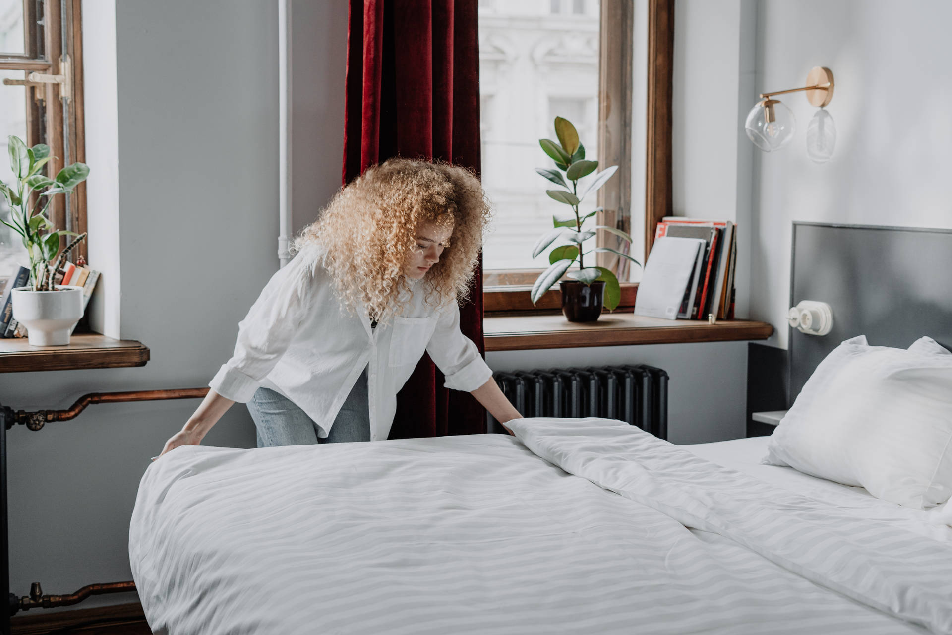 Professional Housekeeper Making The Bed Background