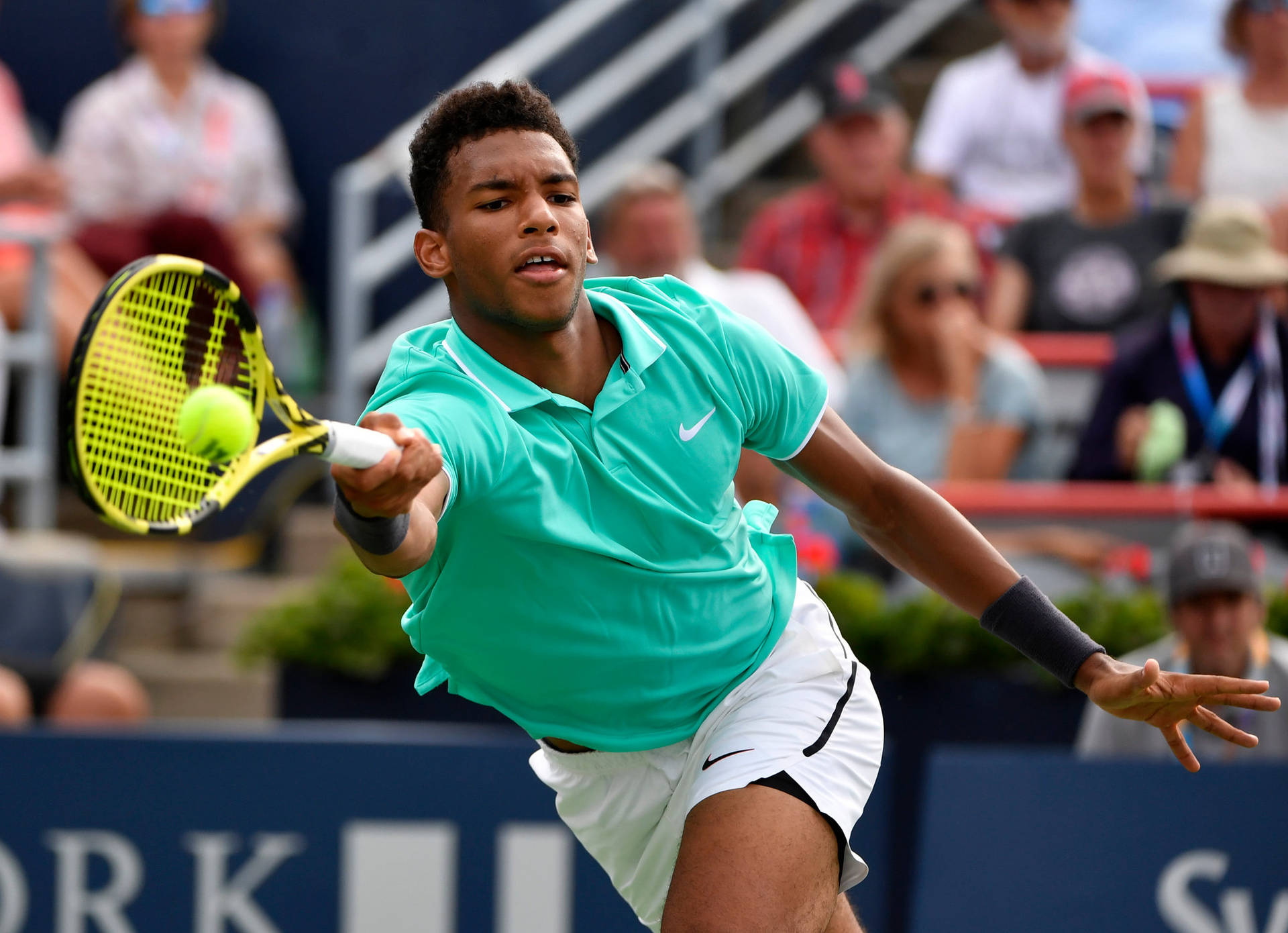 Professional Tennis Player Felix Auger-aliassime Concentrated On Chasing The Ball