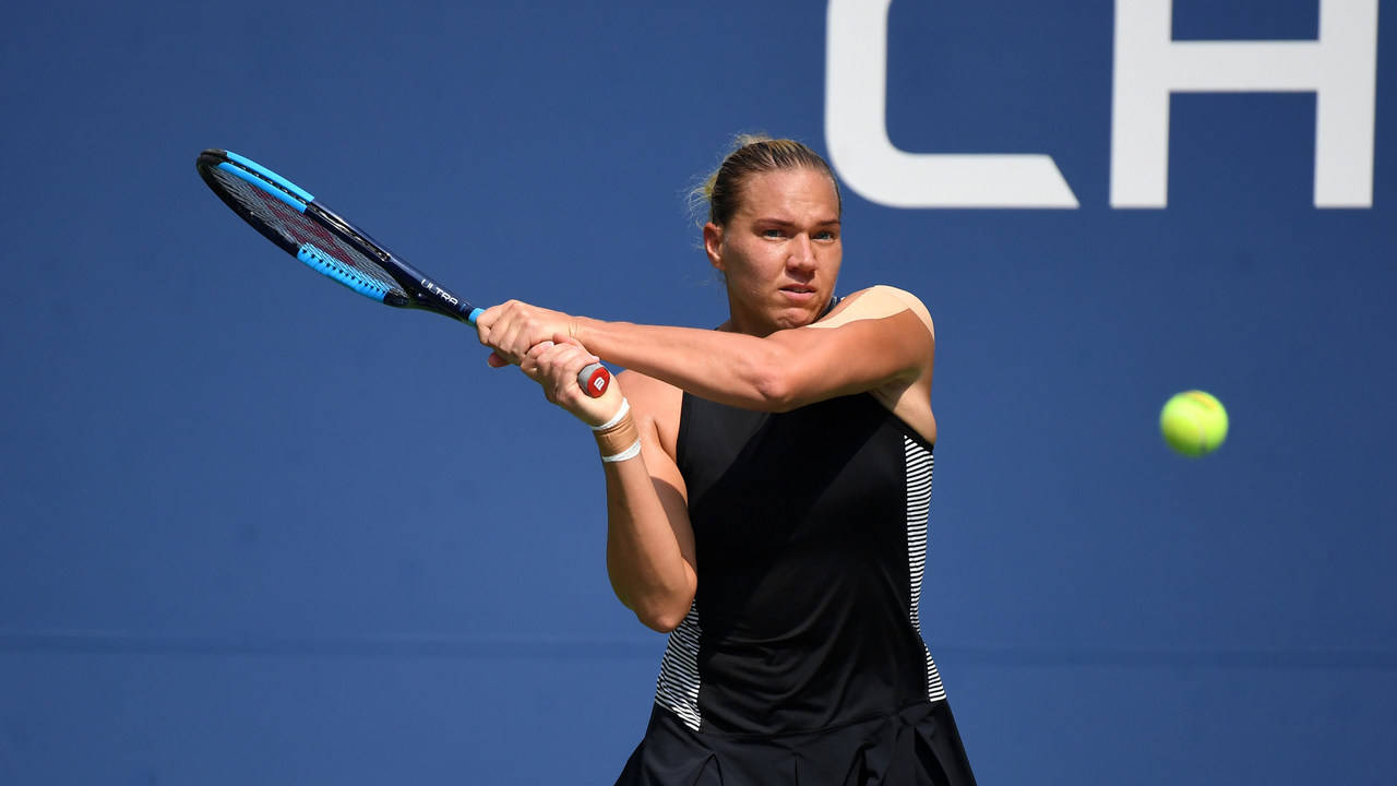 Professional Tennis Player, Kaia Kanepi, Powerfully Striking A Ball Background