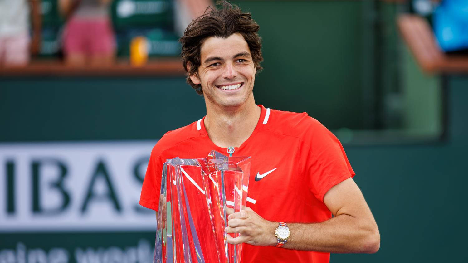 Professional Tennis Player Taylor Fritz Lifting The Tennis Tournament Trophy Background