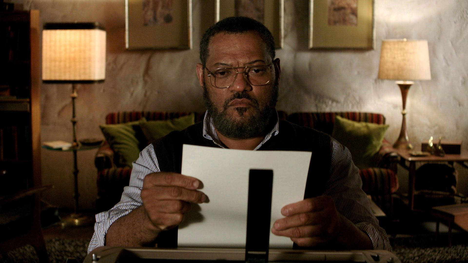 Profound Thespian Laurence Fishburne Deep In Thought While Reading Background