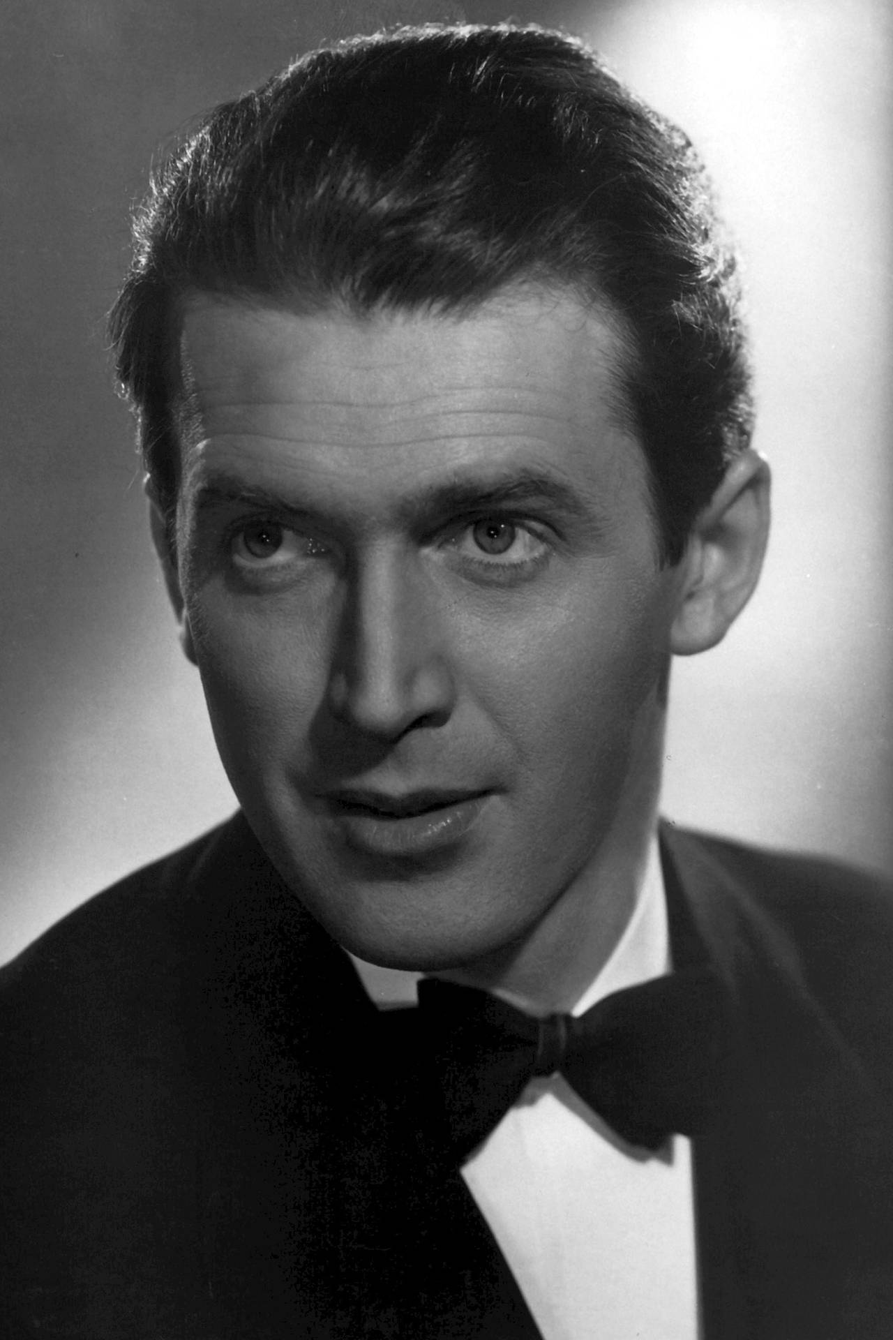 Prolific Actor James Stewart Dressed In A Black Bow Tie Background