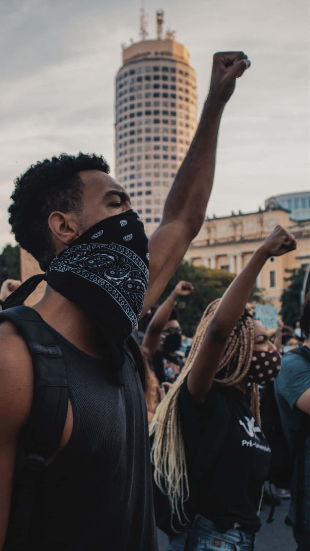 Protesters Raising Fistsin City Background