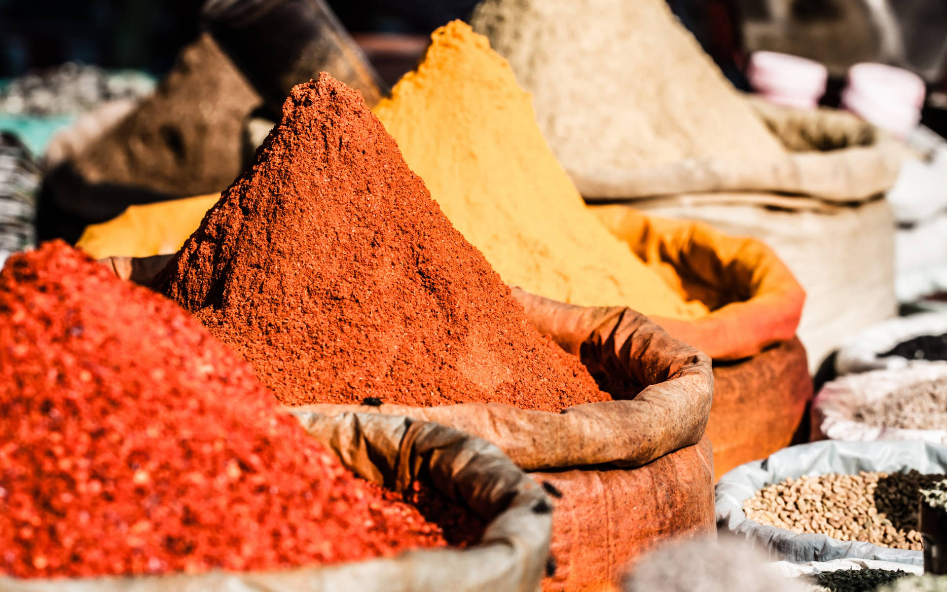 Pungent Powdered Spices In Sacks Background