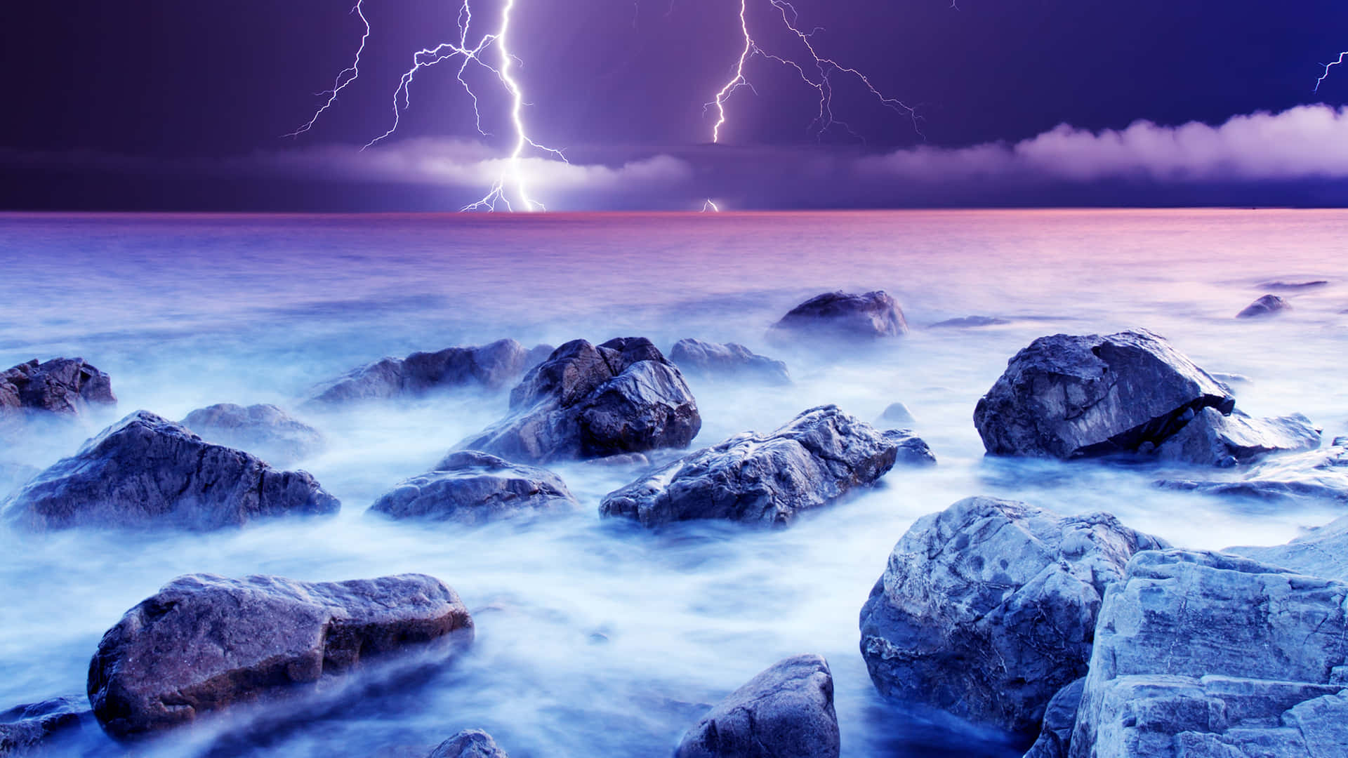 Purple Lightning Over Rocky Sea Background