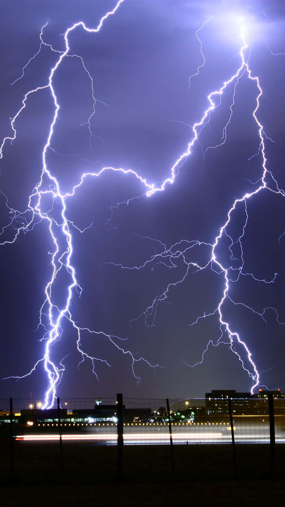 Purple Lightning Strike Against A Dark Sky Background