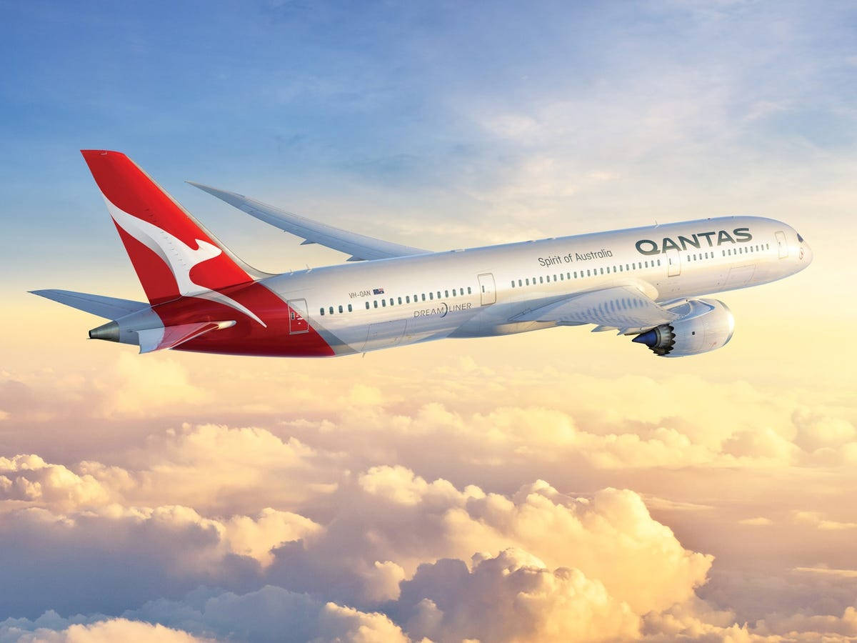 Qantas Aircraft Flying Above The Clouds Background