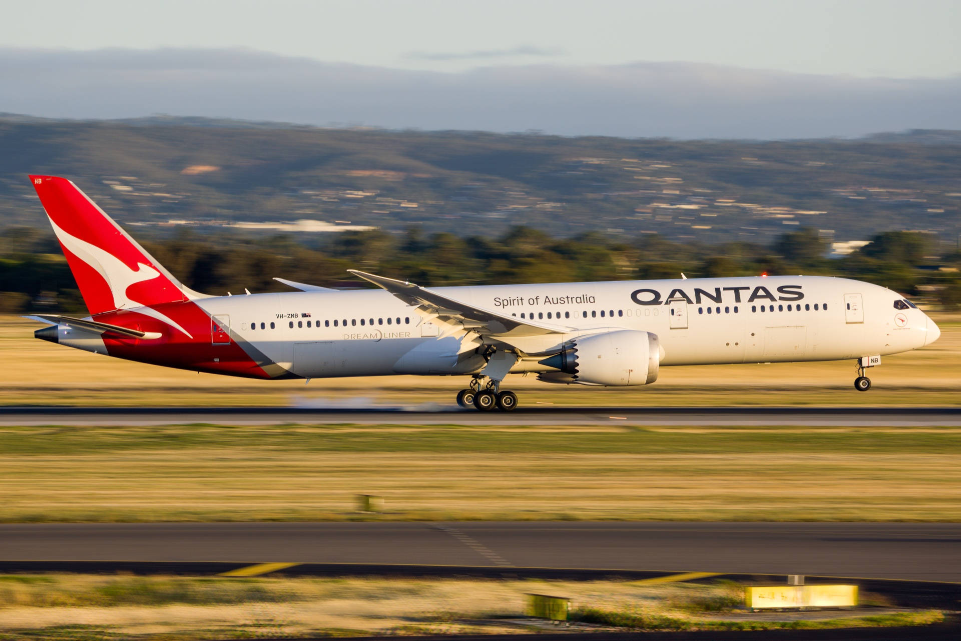 Qantas Airplane Speeding On The Runway Background