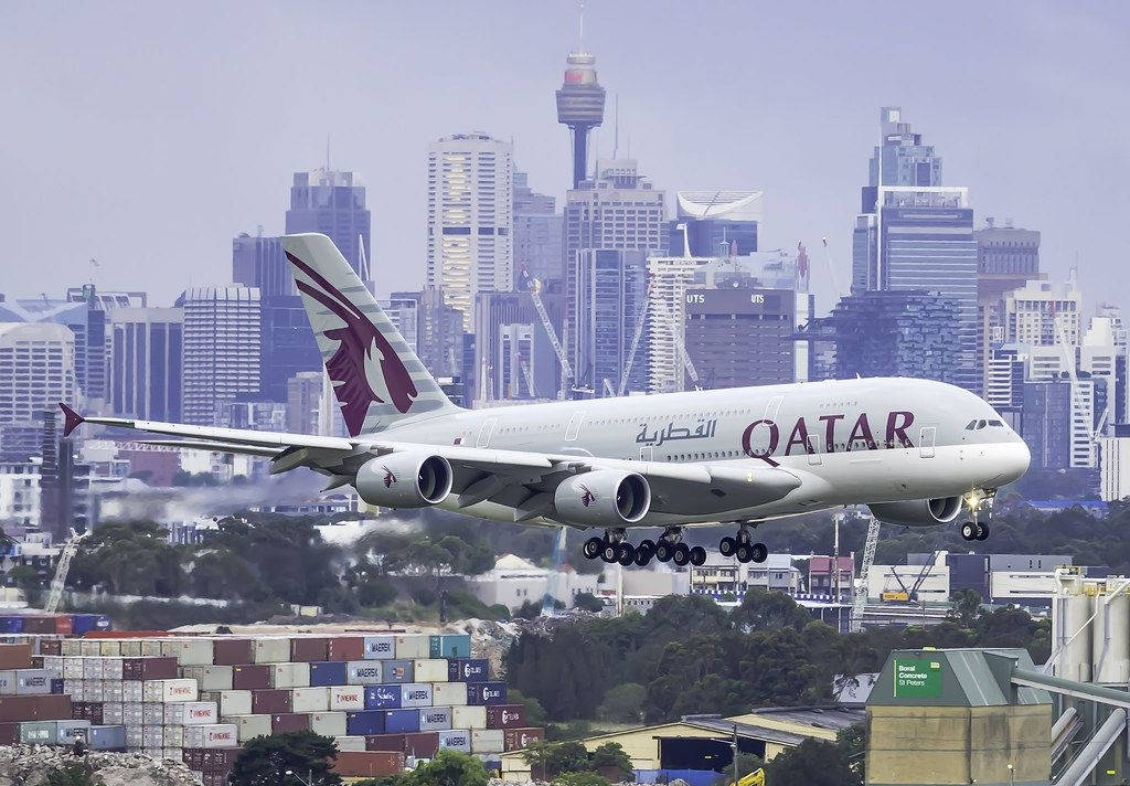 Qatar Airways With A City Landscape Backdrop Background