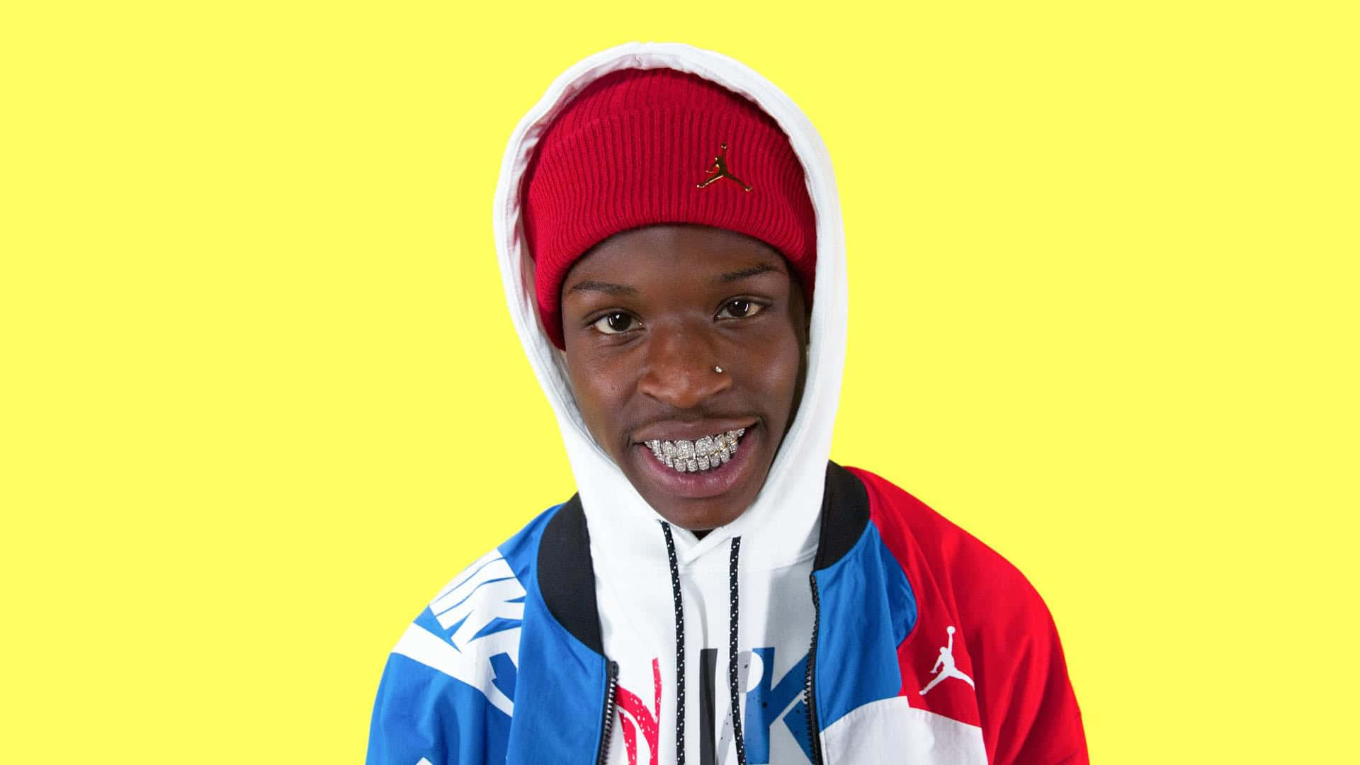 Quando Rondo Striking A Pose With A Vibrant Background Background